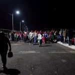 Migrants cross a bridge this morning to enter Mexico.