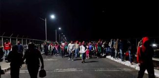 Migrants cross a bridge this morning to enter Mexico.