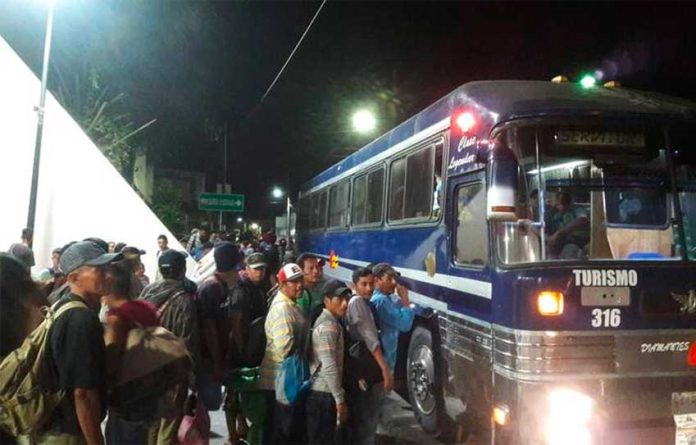 Migrants board a bus in Chiapas.