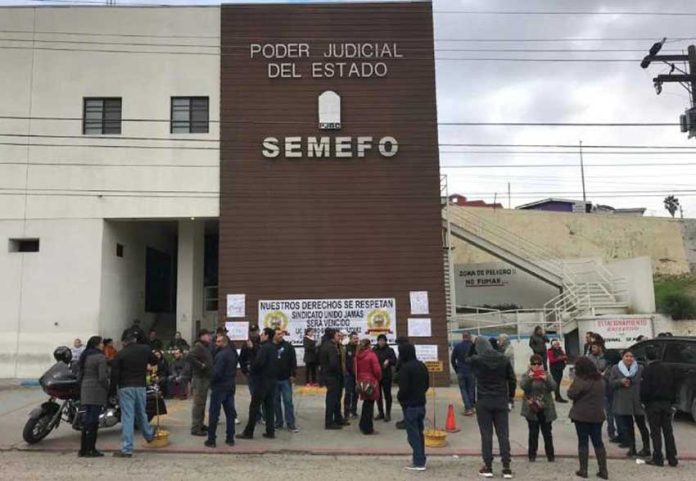 Workers protest against unpaid wages outside the Tijuana morgue in December.