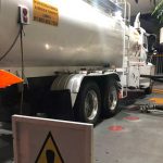 A tanker delivers fuel to a gas station