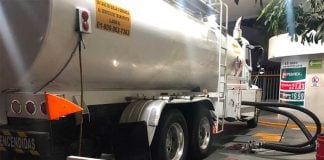 A tanker delivers fuel to a gas station