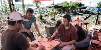 Michoacán teachers enjoy a game of dominoes on the railroad tracks.