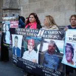 Relatives exhibit photos of missing family members outside the National Palace.