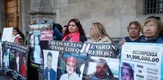 Relatives exhibit photos of missing family members outside the National Palace.