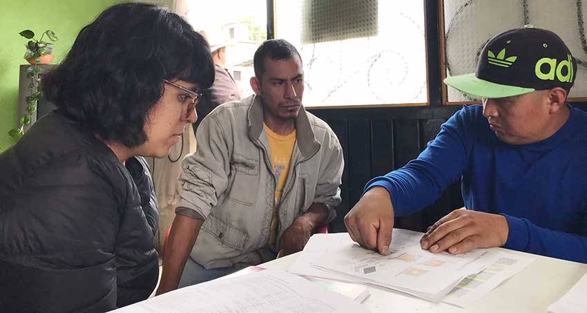 Solano, left, and Noé Lucas, right, discuss plans for an adobe home with Jorge Flores.