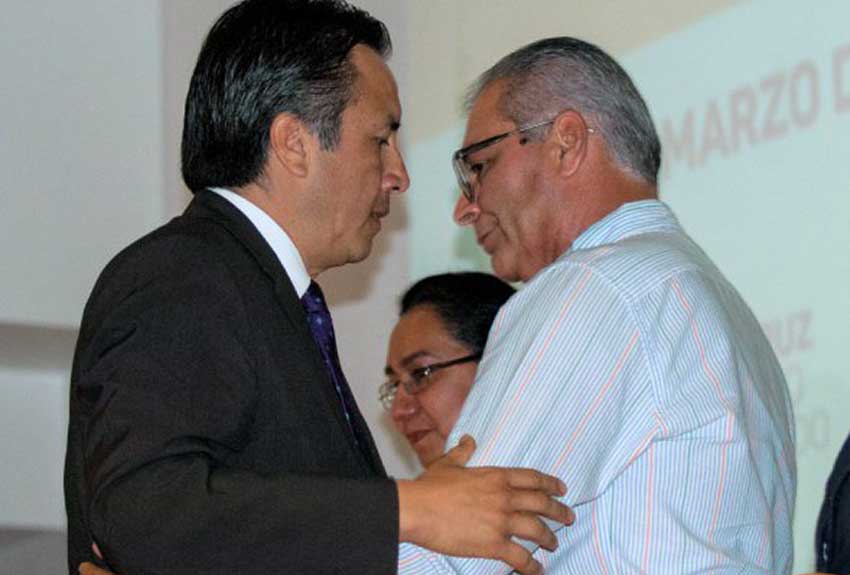 Governor García, left, and parent Benítez embrace during yesterday's ceremony.