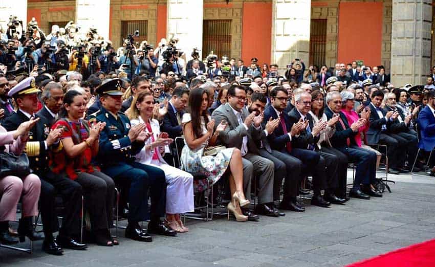 The audience applauds yesterday during the president's 100-day report.