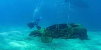 A diver swims near one of the eight vehicles at the bottom of Cabo San Lucas bay.