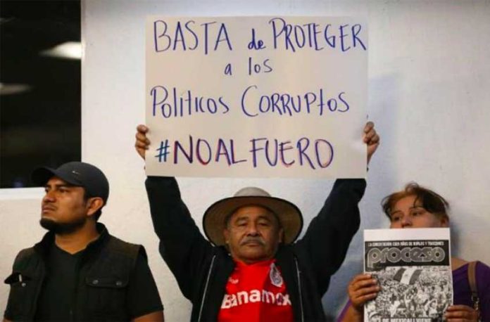 'No more protection for corrupt politicians,' reads the sign of a supporter of eliminating the fuero.