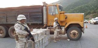 Soldiers stand guard over seized lobster.
