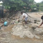 Workers mix concrete on a building project.