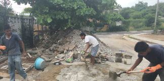 Workers mix concrete on a building project.