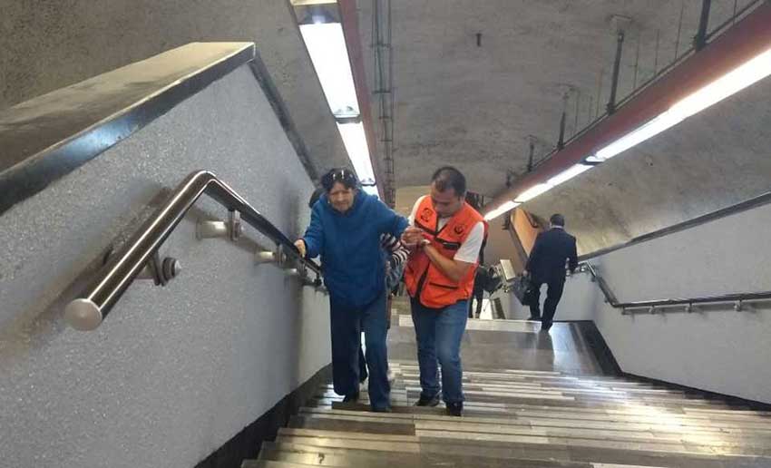 A subway worker provides assistance to a Metro passenger.