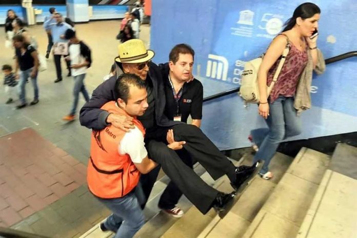 Metro staff carry a subway user up the stairs in Mexico City.