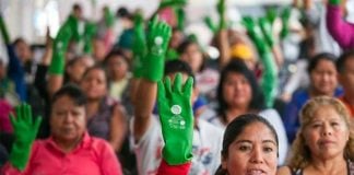 Domestic workers at a rally for better pay and benefits. The green glove is a symbol of the movement.