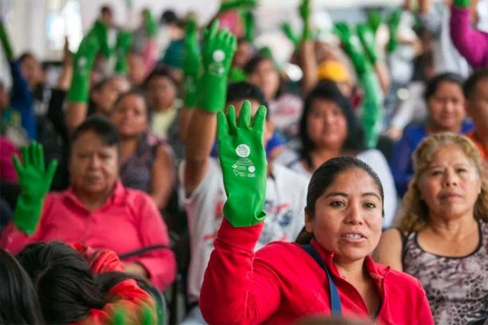 Domestic workers at a rally for better pay and benefits. The green glove is a symbol of the movement.