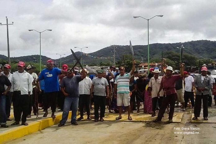 San Dionisio residents raise machetes in protest in 2014.