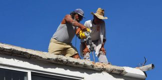 Workers on the roof. Inadvertently cutting an electrical wire cost a Miehle dishwasher.