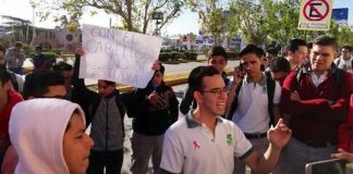 Protesting students in Chihuahua. The sign reads, 'You don't study with your hair.'