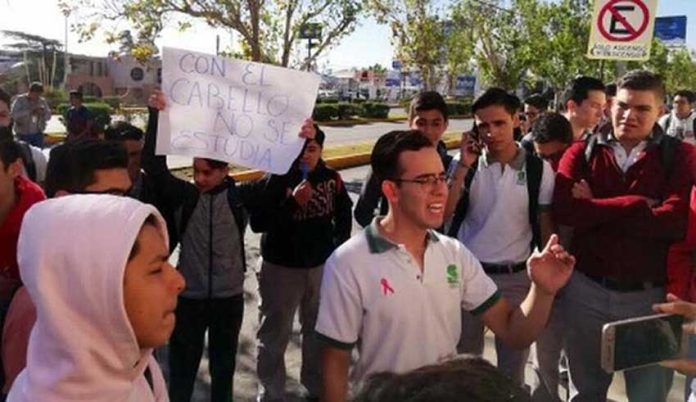 Protesting students in Chihuahua. The sign reads, 'You don't study with your hair.'