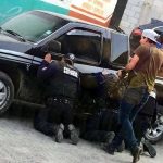 On your knees: Puebla state police forced to kneel by an armed civilian.