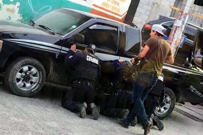 On your knees: Puebla state police forced to kneel by an armed civilian.