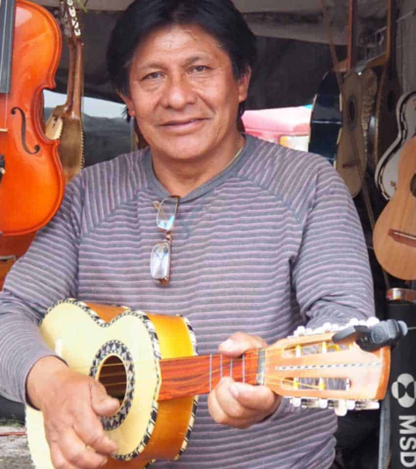 Jorge Rodríguez strums one of the vihuelas he has for sale.