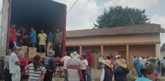 Rather than loot the goods, residents form human chain to load spilled contents in truck.