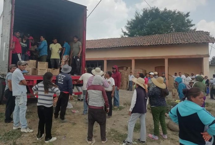 Rather than loot the goods, residents form human chain to load spilled contents in truck.
