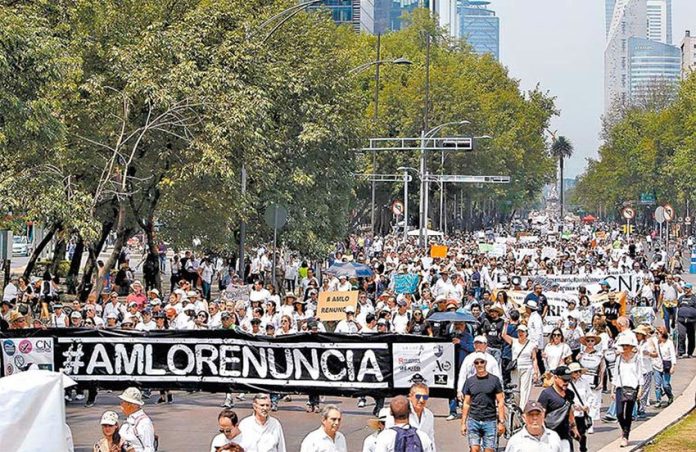 #AMLOresignation, reads the hashtag on the banner at the Mexico City march.