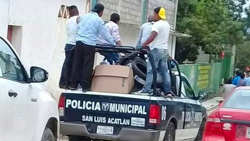 Angry citizens make off with a police vehicle.