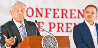López Obrador speaks at his morning press conference as Pemex CEO Romero looks on.