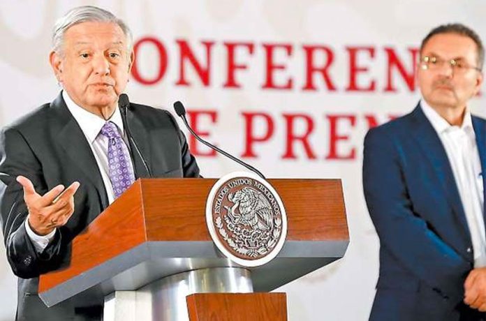 López Obrador speaks at his morning press conference as Pemex CEO Romero looks on.