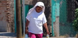 A woman covers up against high temperatures in Hermosillo.