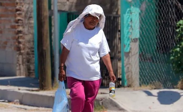 A woman covers up against high temperatures in Hermosillo.