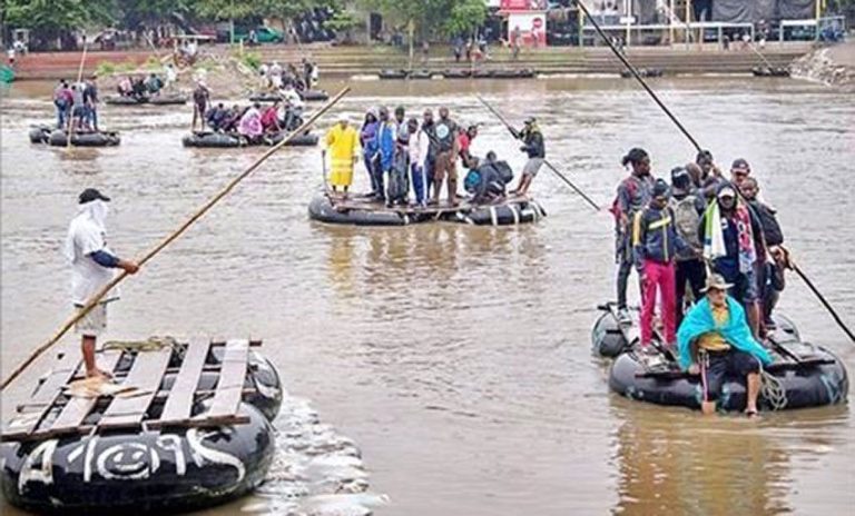 Rafts ferry migrants across the Suchiate river at the Mexico-Guatemala border.