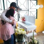 Parents grieve at the coffin of one of the victims of a bacterial infection.