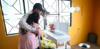 Parents grieve at the coffin of one of the victims of a bacterial infection.