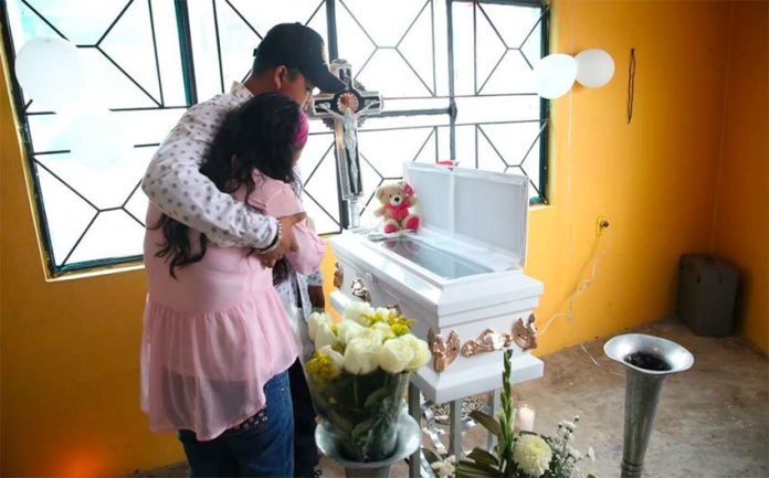 Parents grieve at the coffin of one of the victims of a bacterial infection.