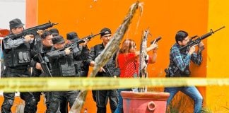 Police take aim during a shooting yesterday Jalisco.