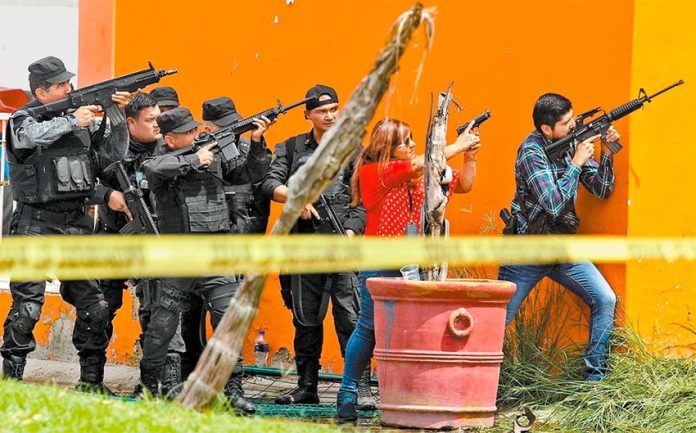 Police take aim during a shooting yesterday Jalisco.