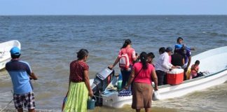 Santa María residents board a boat to reach their homes.
