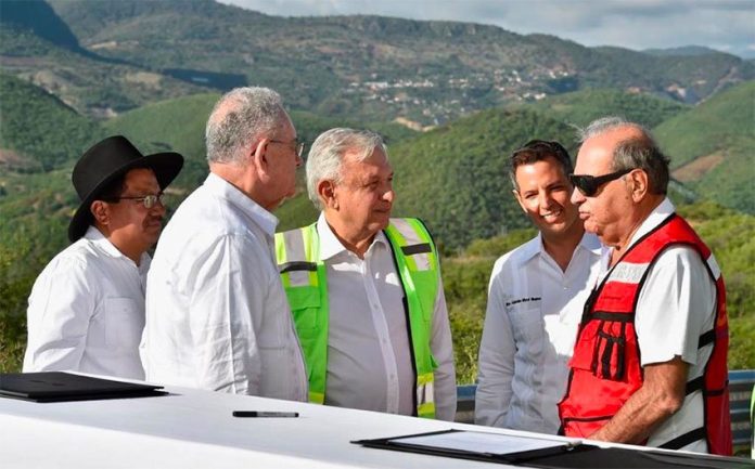 López Obrador, center, chats with Slim, right, while signing a highway construction contract on Friday. Between them is Oaxaca Governor Alejandro Murat.