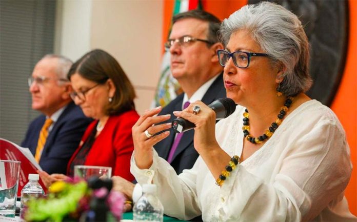 Ebrard, center, listens as Economy Secretary Graciela Márquez addresses the press conference.