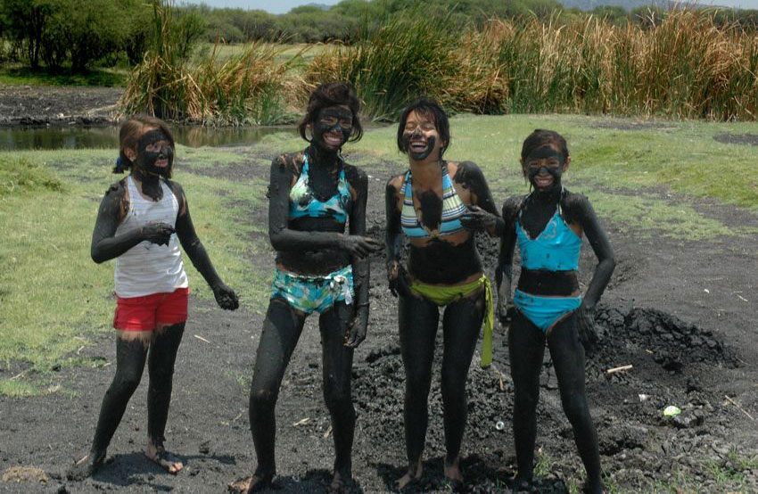 Four friends having fun in the mud.