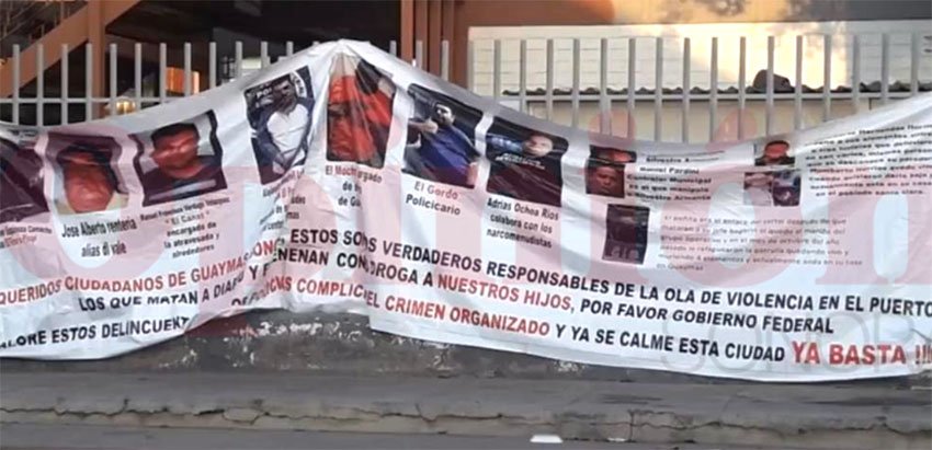 The banner identifying alleged criminals was hung this morning outside a school.