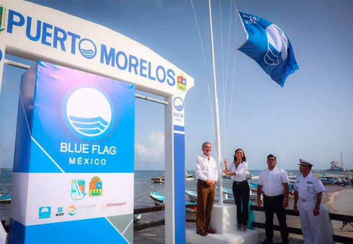 Mayor raises the blue flag over a Puerto Morelos beach.