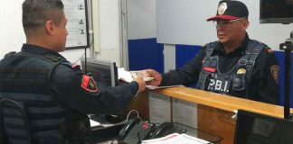 The unidentified officer, right, turns in the cash.