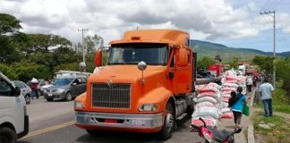 Sacks of looted fertilizer are stacked on the roadside ready for farmers.